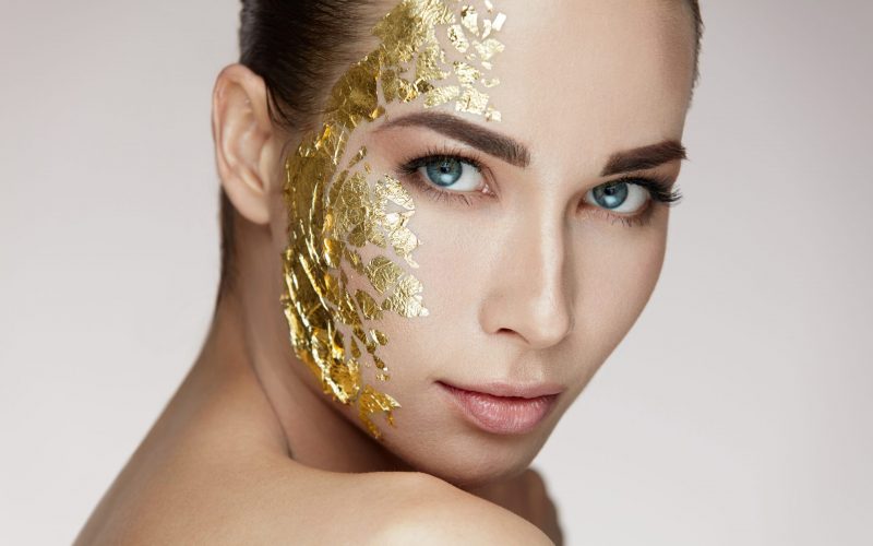 Beauty Woman Face Masking. Girl With Gold Mask On Soft Skin Gold Mask On Soft Skin